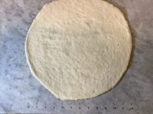 Pizza dough rolled out into a round