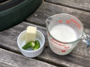 Fresh jalapeños and a measuring cup of heavy cream