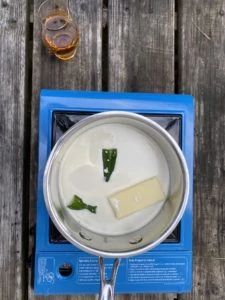 Jalapeños and butter steeping in cream in a saucepan