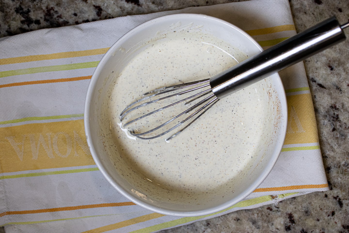 White BBQ Sauce in a bowl with a Whisk
