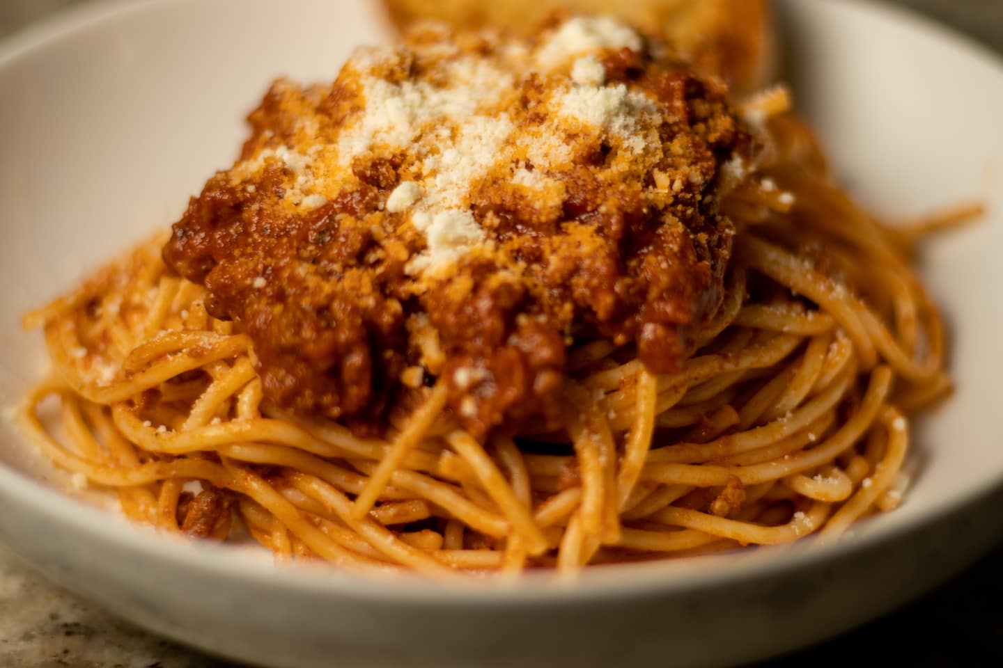 Spaghetti in a bowl topped with grated cheese