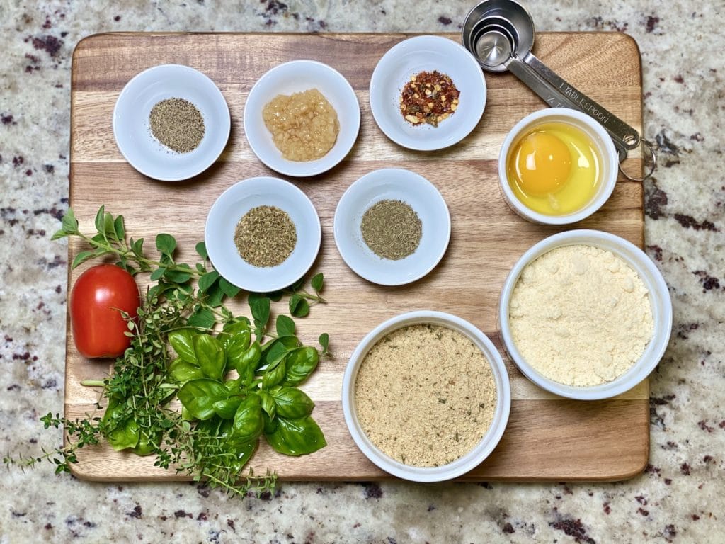 Ingredients for meatballs on a wooded board. 
