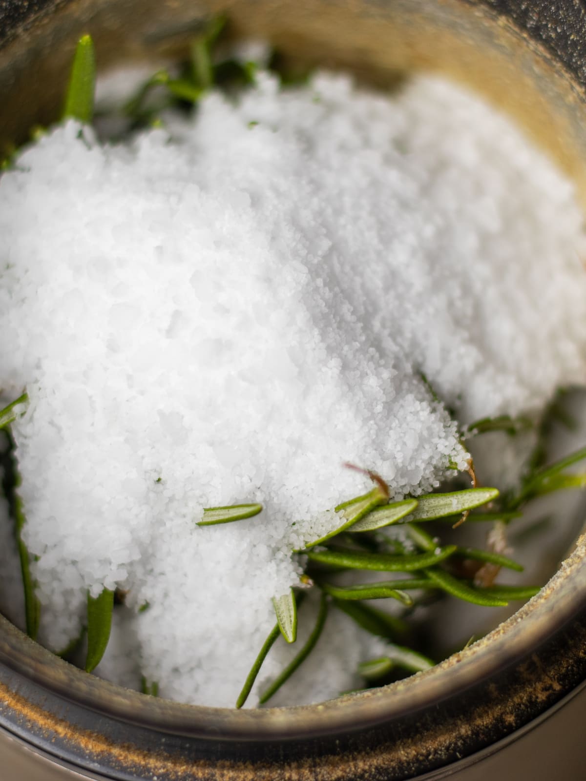 Kosher salt over rosemary leaves