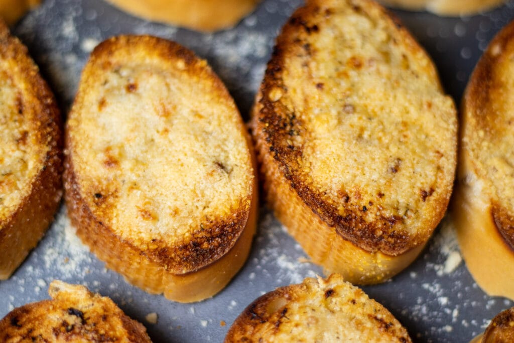 Close up of toasted garlic bread with browned parmesan cheese