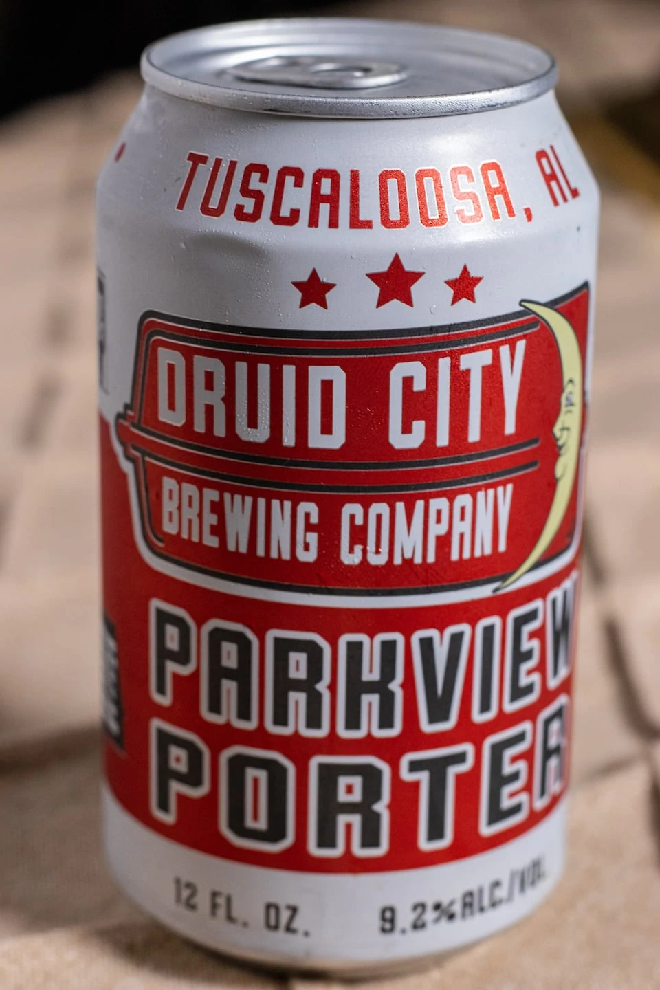 Beer can with Tuscaloosa, AL at top in red on a white background, three red stars before it transitions to white text on a red background that says "Druid City Brewing Company" with a yellow crescent moon with a smiling face on it. Then black text outlines in white that says "Parkview Porter" Bottom of the can says 12 ounce and 9.2% ABV.