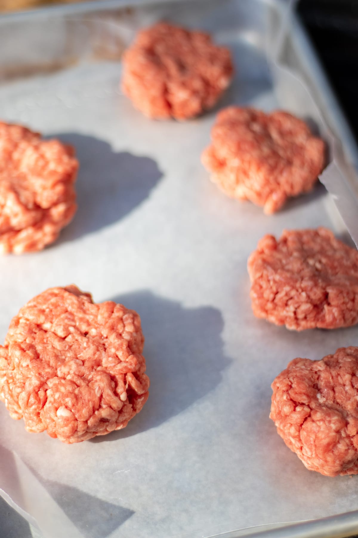 raw smash burger patties on wax paper ready to cook