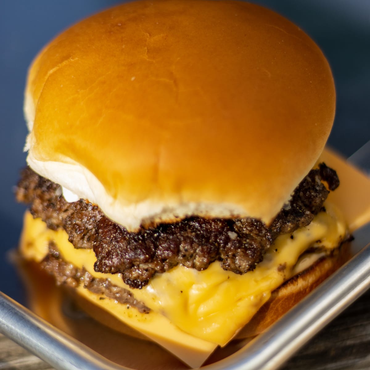 double cheeseburger on a metal tray.