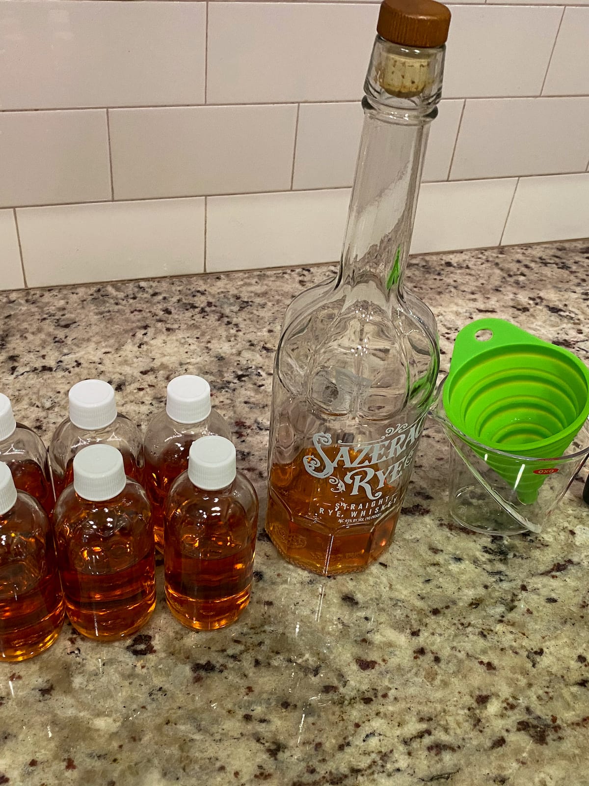 A bottle of Sazerac Rye being poured into advent bottles