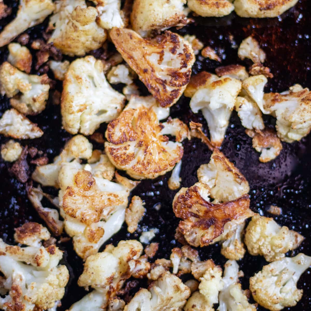 roasted cauliflower on a dark cookie sheet