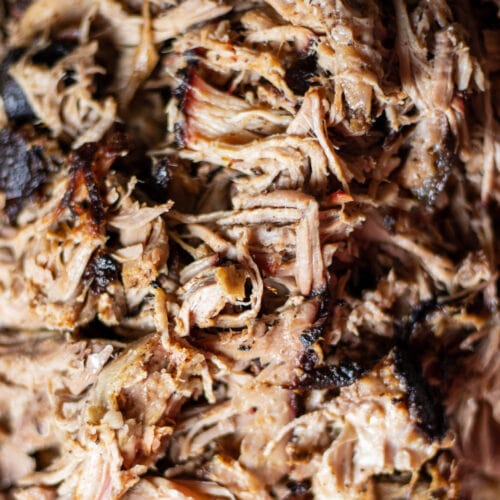 pulled pork close up with bark on a platter.