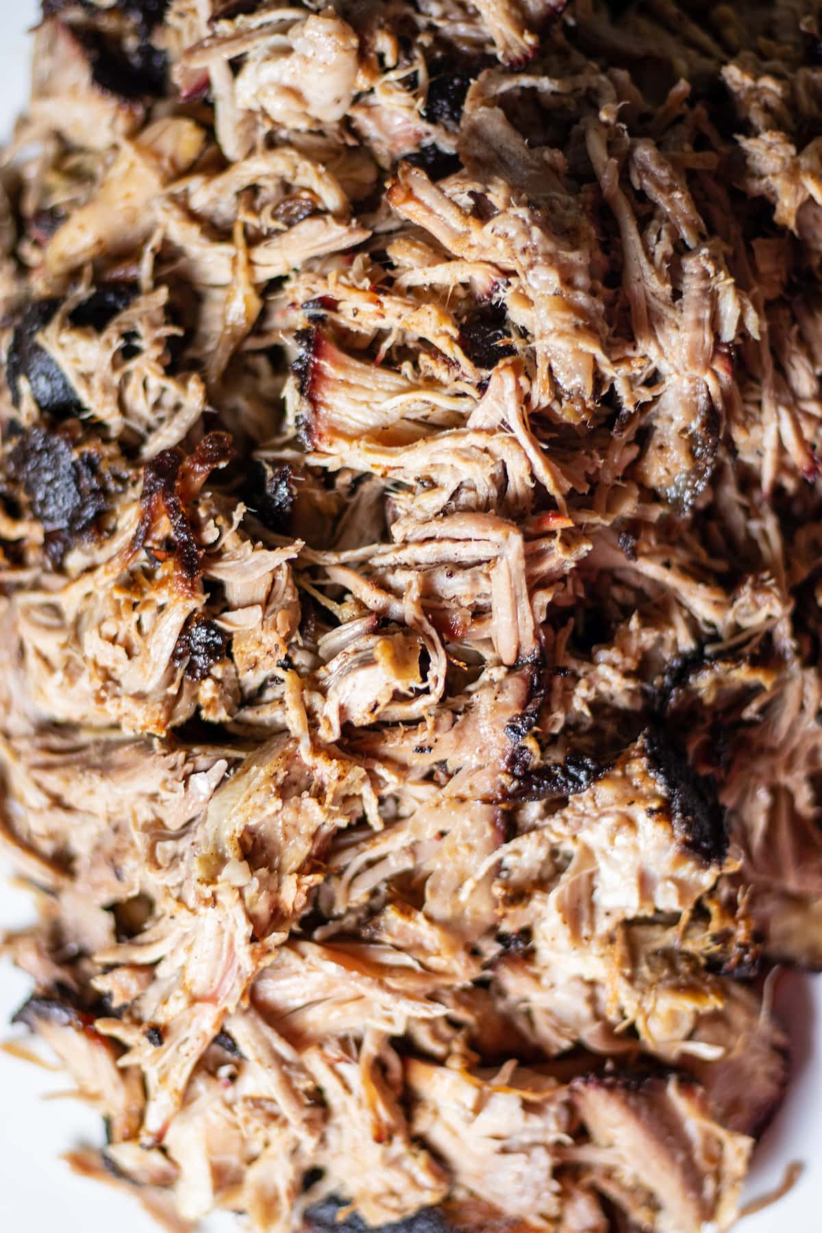 Close up of pulled pork on the big green egg with bark mixed in. 